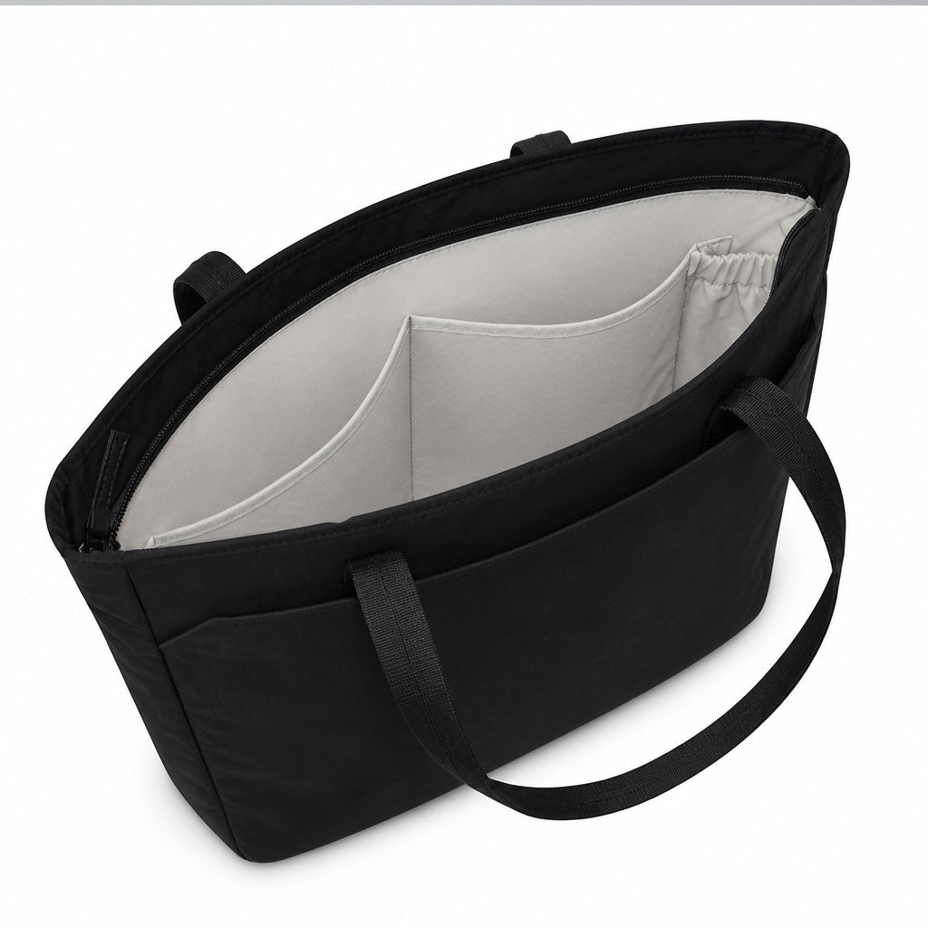 Light-colored lining and interior slip pockets inside the black zip-top tote.
