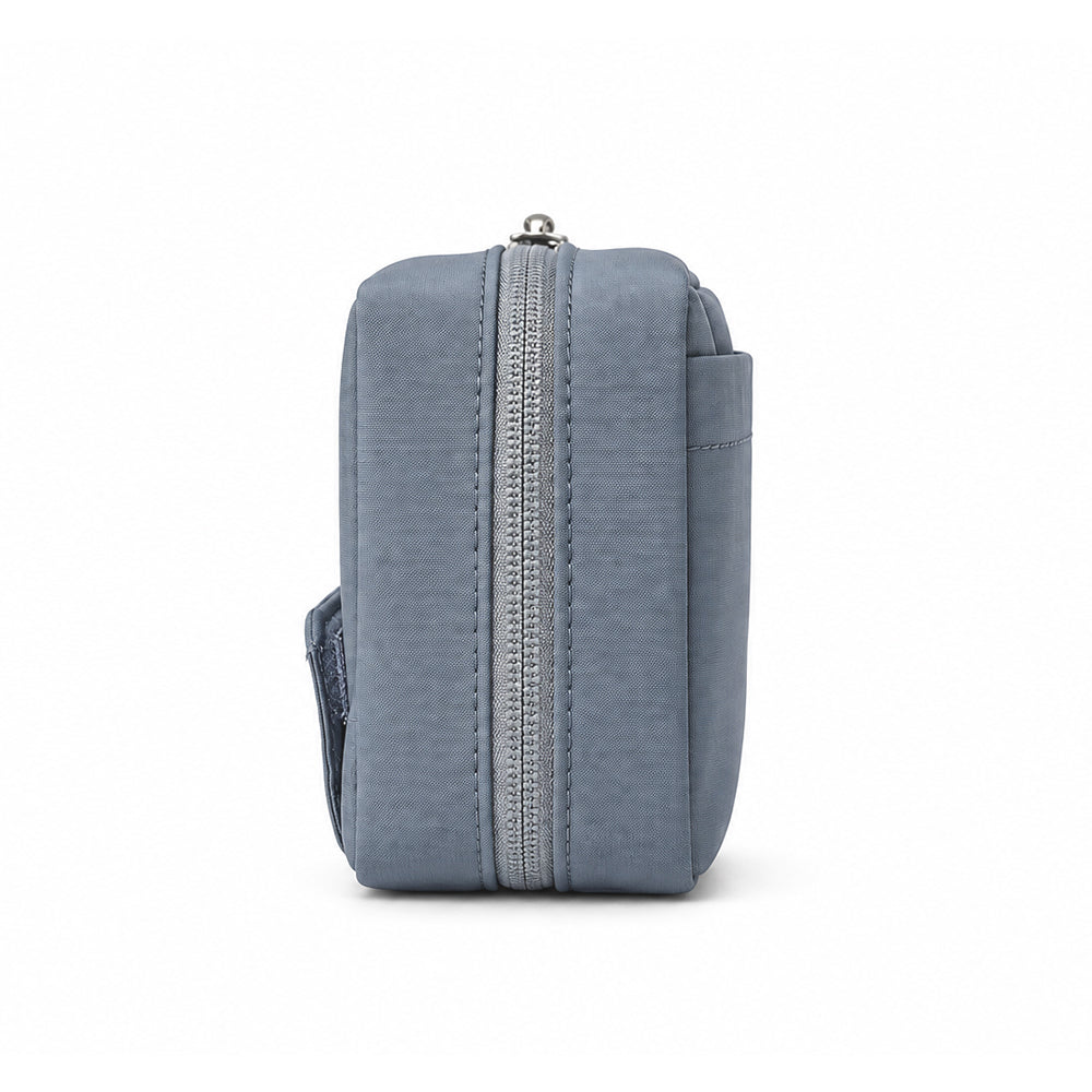 Side view of the blue-gray tech pouch showing its slim profile and zipper.