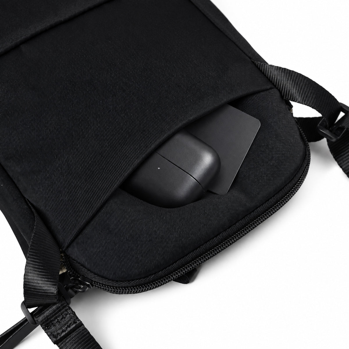 Rear pocket of the black compact crossbody bag.